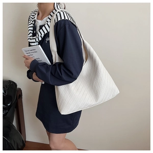 Side view of white woven leather hobo bag showing large capacity and soft texture