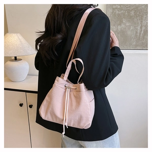 Close-up of light pink nylon drawstring bucket bag with soft texture and shoulder strap