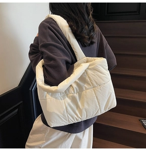 Détail du sac cabas matelassé blanc montrant la texture en nylon rembourré et la sangle
