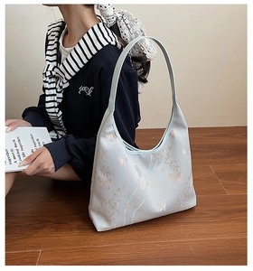 Détail du sac bandoulière bleu clair avec broderie dorée de papillons et bambous