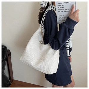 Detail of white woven hobo tote bag featuring minimalist V-shape texture and large capacity