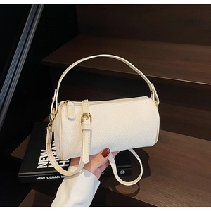Detailed close-up of white lychee leather texture and gold zipper on Boston bag