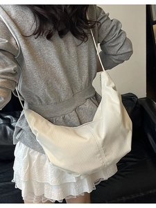 Minimalist beige corduroy hobo bag with crescent moon shape and silver zipper closure