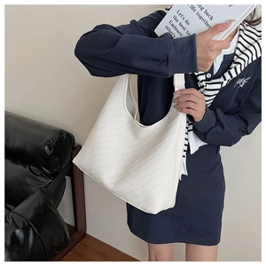 Detail of white hobo bag showing woven herringbone texture on a large shoulder tote