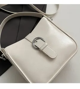 Detailed macro view of beige textured faux leather bag with silver round buckle closure