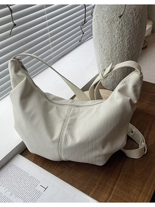 Minimalist beige dumpling hobo bag with pleated texture and adjustable wide shoulder strap