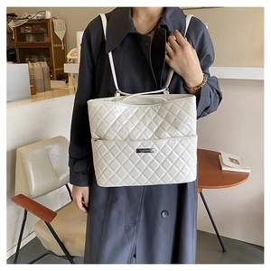 Close-up of white quilted tote bag featuring metallic YOUBER logo and slender shoulder straps