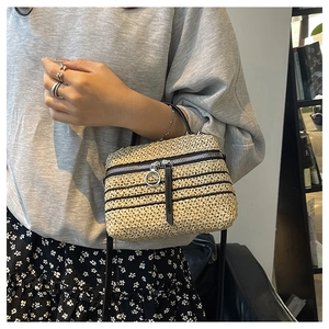 Détail du sac bandoulière en paille tissé main avec rayures noires et anneau argenté