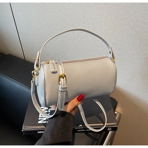 Close-up of silver-grey litchi grain leather pillow bag with gold hardware and zipper detail