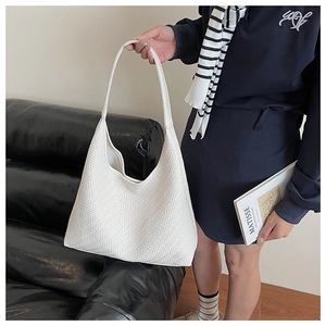 Close-up of white tote bag featuring refined V-shaped geometric woven texture and minimalist style