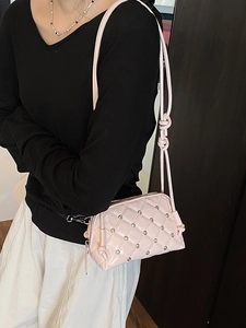 Pink quilted crossbody bag with rhinestone details and stylish knotted shoulder strap