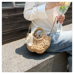 Detail of semi-circular straw bag with lace ribbon and drawstring liner for beach