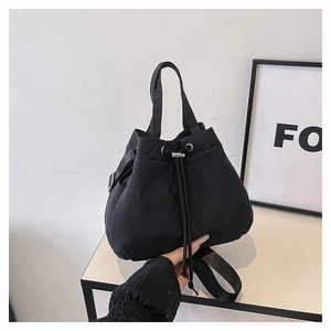 Detailed view of black nylon drawstring bucket bag with adjustable shoulder strap and handle