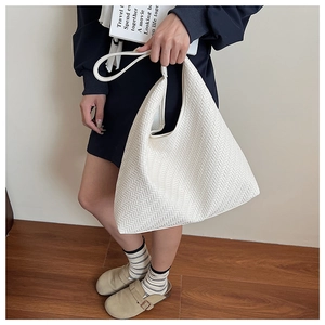 Detail of a large white woven tote bag featuring an herringbone texture for daily use