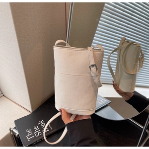 Close-up of white lychee pattern mini bucket bag with adjustable strap and silver buckle