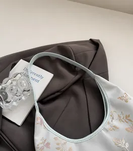 Primer plano del bordado de mariposa y la correa suave en este bolso de estilo chino