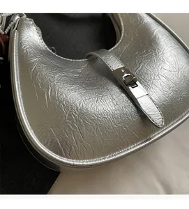 Detailed close-up of metallic silver crinkled texture bag with elegant metal turn-lock
