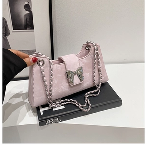 Détail du sac à bandoulière rose avec boucle nœud argentée et bandoulière chaîne