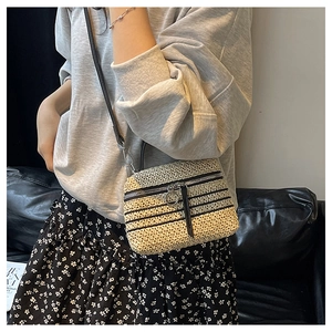Détail d'un sac bandoulière tissé à la main beige et noir avec fermeture éclair en métal
