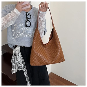 Close-up of the intricate V-shaped woven texture on this caramel brown leather hobo bag
