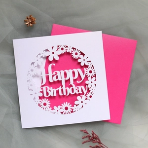 Detail view of laser-cut Happy Birthday card with daisies and a pink envelope