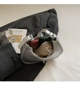 Silver metallic dumpling bag showing large capacity for phone, wallet and umbrella