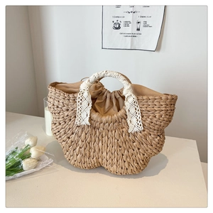 Detail of woven straw bag featuring lace-wrapped handle and secure drawstring lining