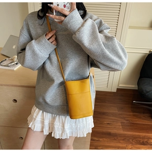 Close-up of bright yellow litchi pattern leather crossbody phone bag on a model