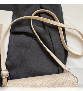 Détail de la bandoulière lisse et de la texture tissée d'un sac bandoulière beige