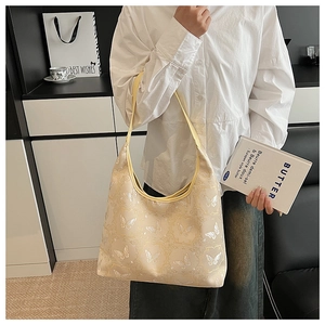 Détail du sac hobo avec motifs papillons blancs et bandoulières en cuir jaune clair