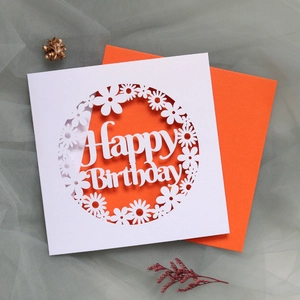 Macro view of laser-cut daisy hollow pattern and Happy Birthday greeting on card