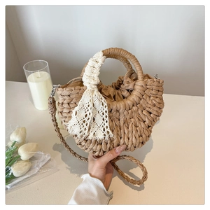 Detail of semi-circular straw bag with lace ribbon and drawstring inner lining