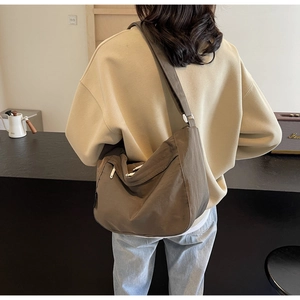 Coffee brown hobo crossbody bag with large capacity and pleated nylon design shown on model