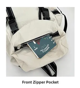 Detailed view of the beige travel backpack featuring a front zipper pocket and black buckle