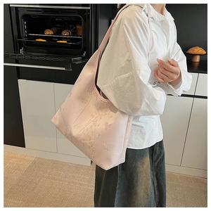 Detail of light pink tote bag with elegant bamboo and butterfly jacquard patterns