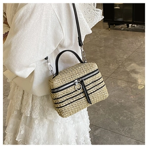 Détail du sac à bandoulière en paille tressé main avec poignée cuir et fermeture éclair