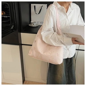Détail d'un sac cabas rose brodé avec motifs papillons et intérieur spacieux