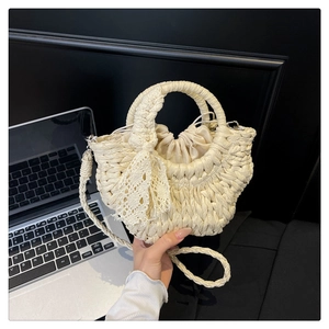 Detailed close-up of woven semi-circle handbag with lace bow and drawstring closure