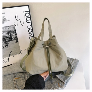 Detail of drawstring bucket bag in olive green nylon with adjustable shoulder strap