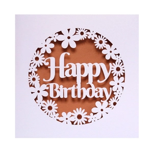 Intricate laser-cut white card with Happy Birthday text and daisy patterns