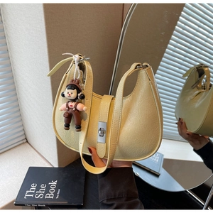 Light yellow crescent bag with pleated texture and silver buckle, including doll charm