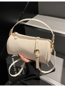 Minimalist white cylinder pillow bag in lychee pattern leather with golden hardware