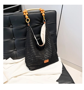 Detail of black crochet tote bag featuring artisanal wood bead handle and woven texture