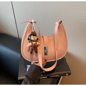 Detail of pink pleated hobo bag with silver buckle and cute cartoon doll charm pendant