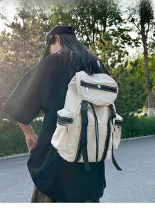 Outdoor shot of a beige tactical backpack featuring multiple utility pockets and buckles