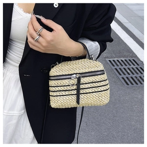 Détail du sac à main en paille tressée avec rayures noires et fermeture éclair à anneau