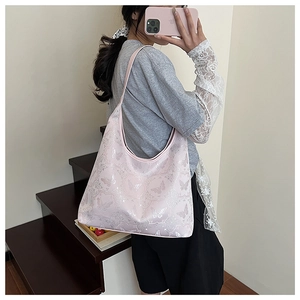 Detail view of pink shoulder bag with butterfly jacquard floral embroidery on model