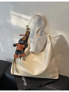Creamy white glossy hobo bag with a cute leather cat pendant and minimalist aesthetic