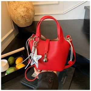 Detalle del bolso de cubo rojo con textura de lichi y colgante de estrella plateada