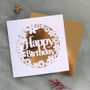 Macro detail of laser-cut Happy Birthday card with elegant daisy floral patterns